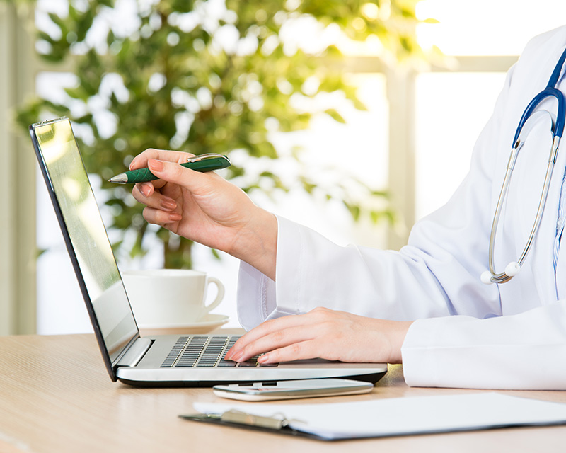 Spiritual and Wellness Nurse coach sitting at a laptop for a virtual session