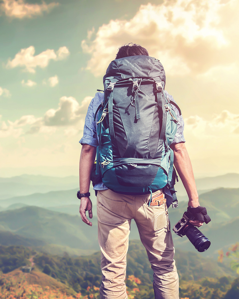 Person with a backpack and camera on a hike